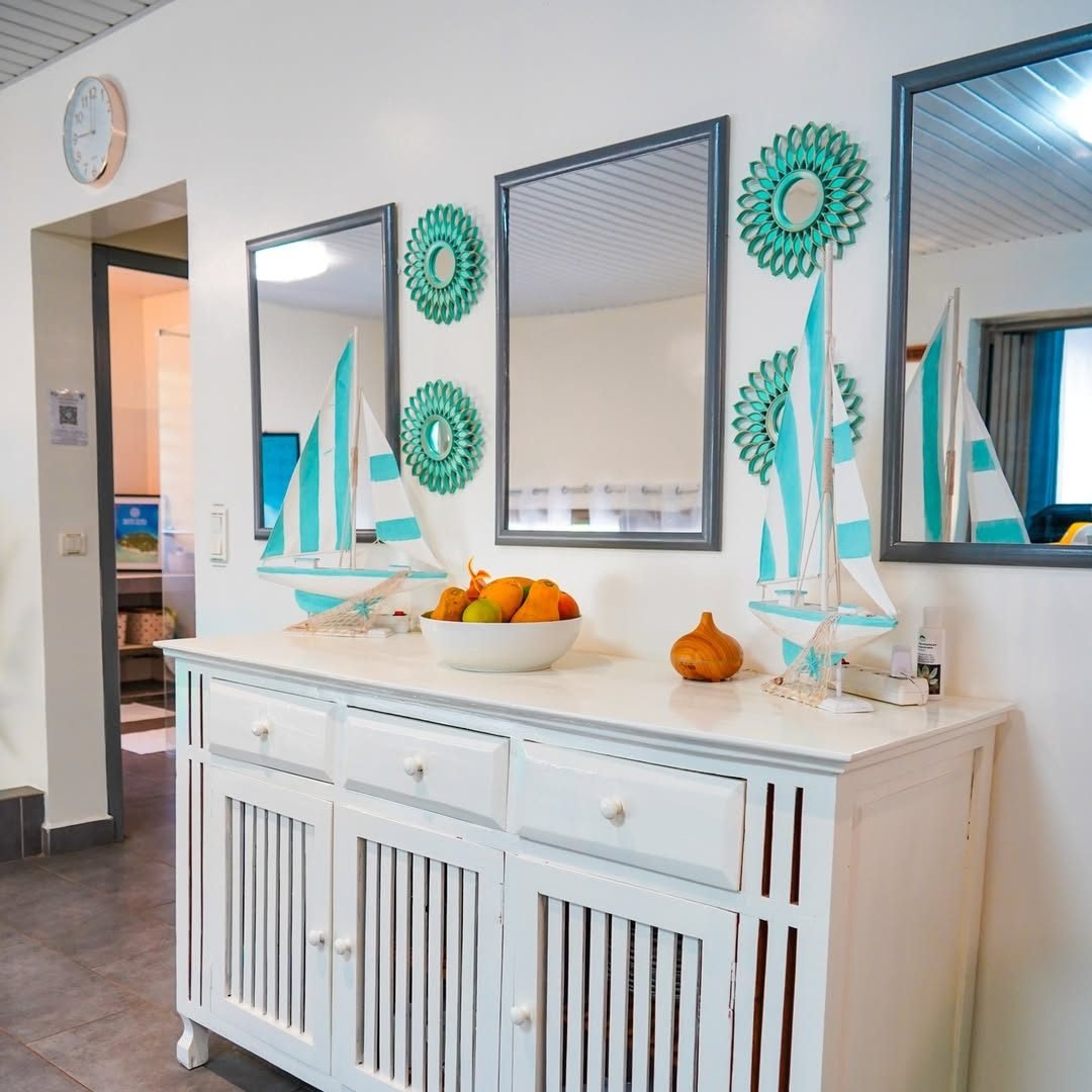 Entrée avec commode blanche, miroirs et voiliers décoratifs